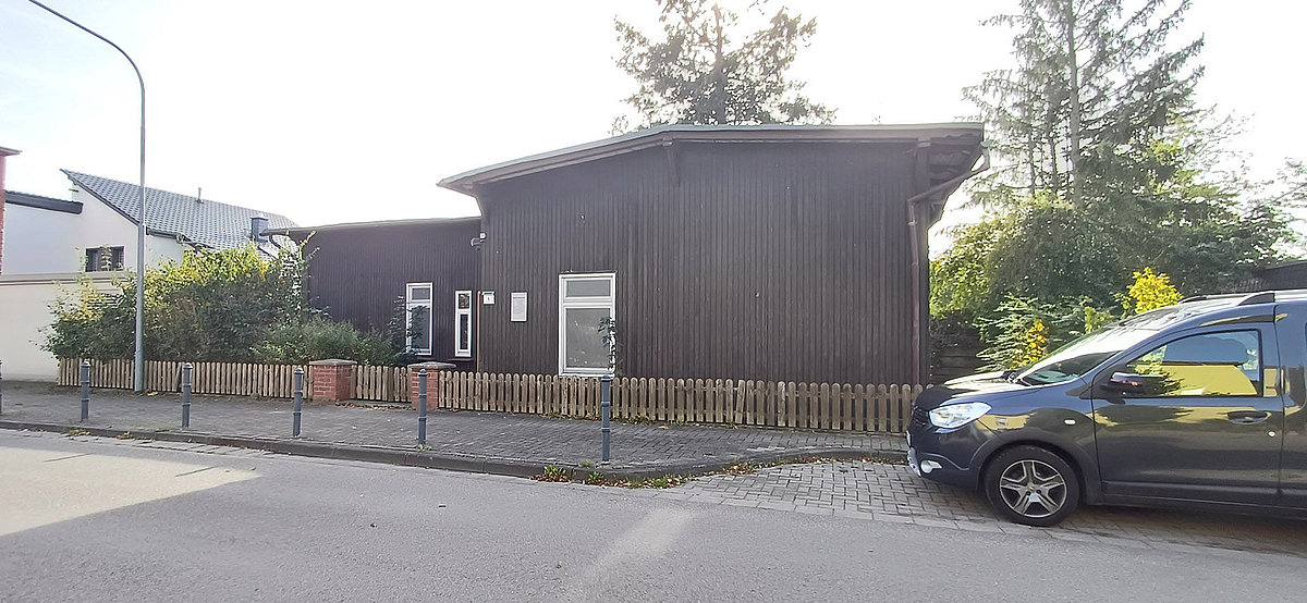 Ehemaliges kleines Krankenhaus in Holzbauweise mit Lattenzaun