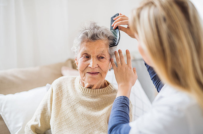 Pflegekraft kämmt Seniorin die Haare im Käthe-Kollwitz-Haus